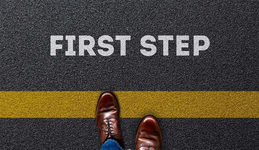 The words first step on a road with shoes in the frame.